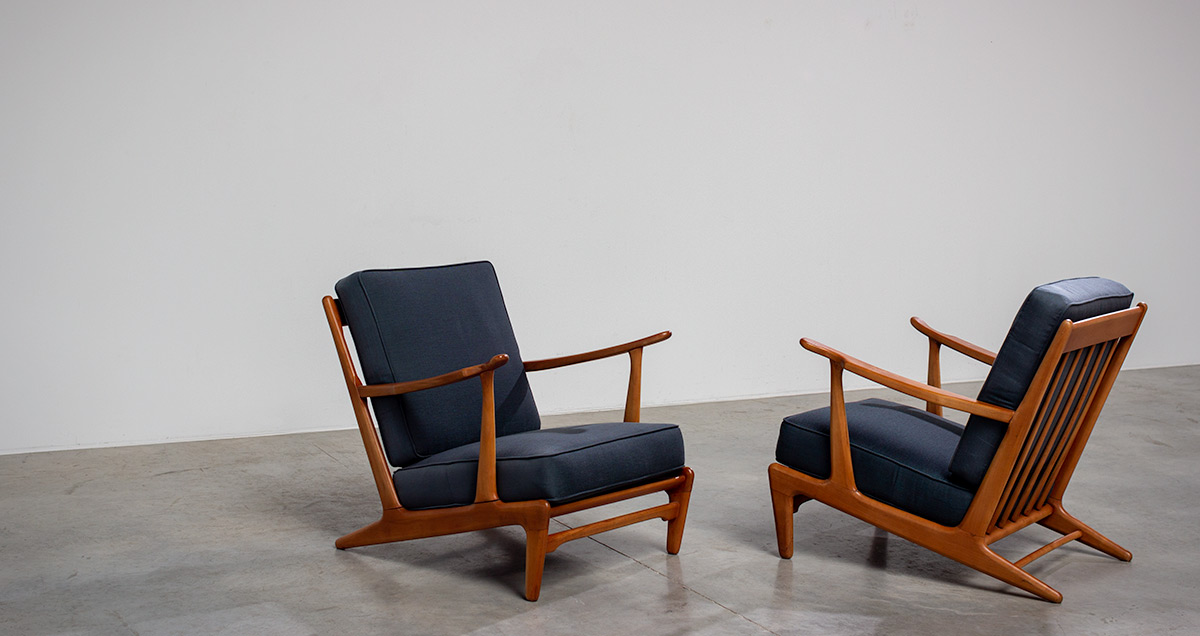 Pair of sculptural Scandinavian lounge chairs. The frame shows beautiful lines with arms that point slightly upwards are both sweeping and elegant. The most distinctive feature within these armchairs are the armrests that have rhythmic slats.